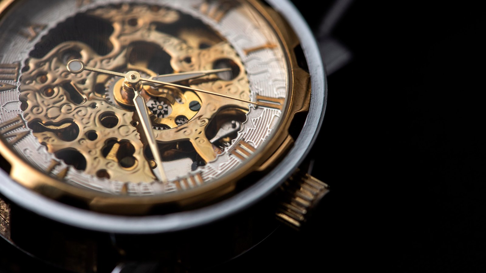close-up shota of skeleton watch with golden dial.