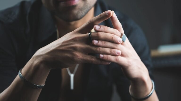 .Close-up of a man's hands wearing affordable men’s jewellery in Pakistan including rings, bracelets, and a necklace.